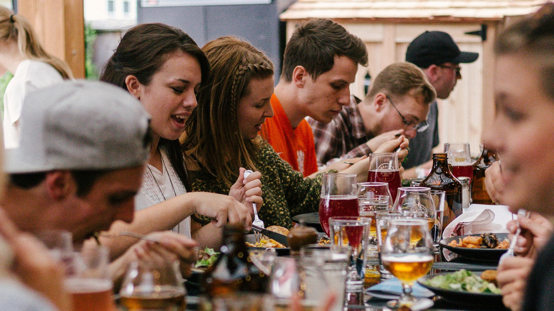 Group of people at a long table full of drinks and food